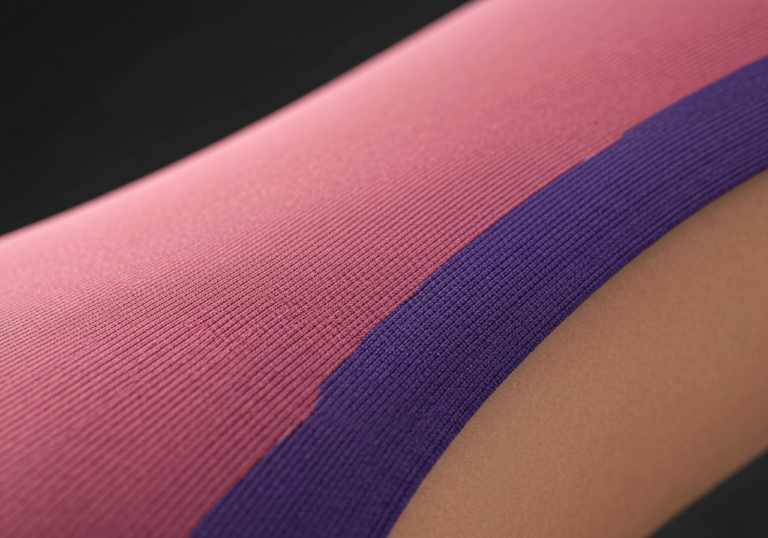 Zbliżenie na rozciągający się elastyczny materiał na ciele ukazujący strukturę włókien.