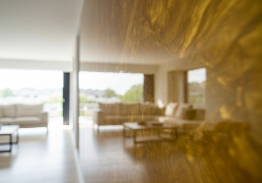 Ściana z żywicy epoksydowej o gładkiej, błyszczącej powierzchni w nowoczesnym, jasnym wnętrzu.